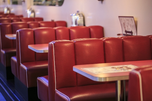 Booths in a restaurant create a private dining experience in a crowded room.