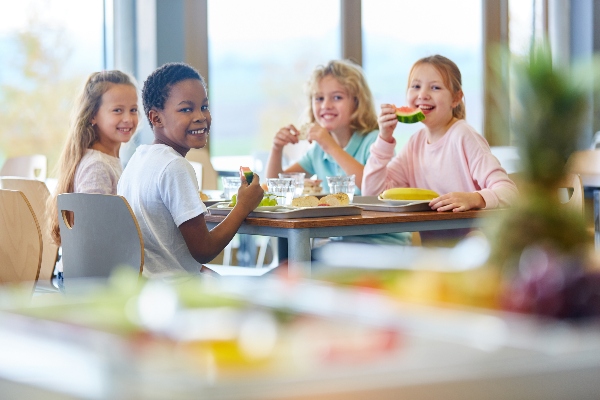 A happy group of kids enjoy their recently remodeled school cafeteria.